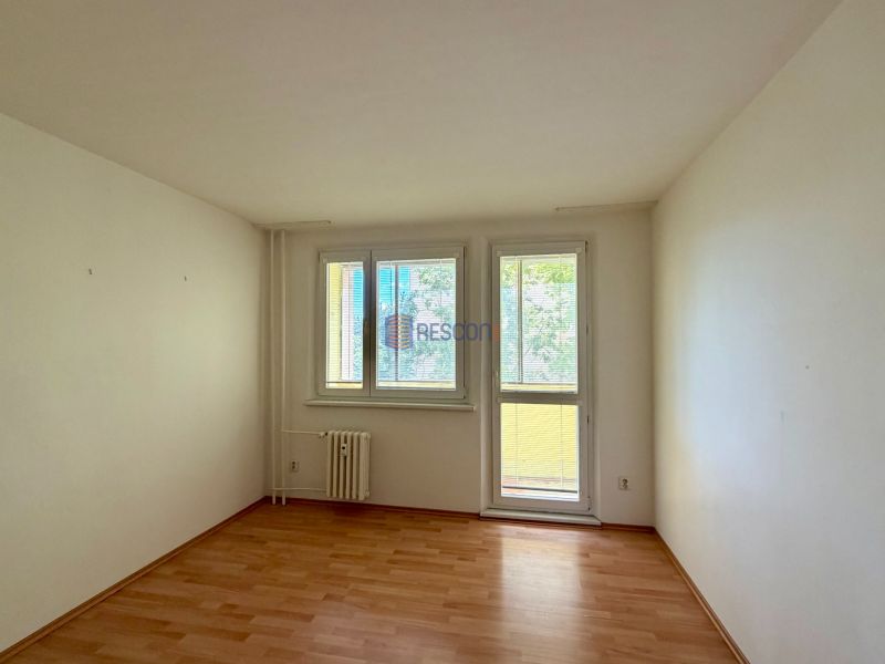 A room with light walls and a floor with a wood decor in a 4-room apartment.