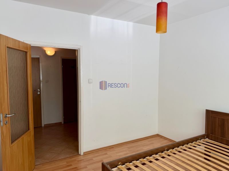 Bedroom in a 4-room apartment with a bed and a wooden decor floor.