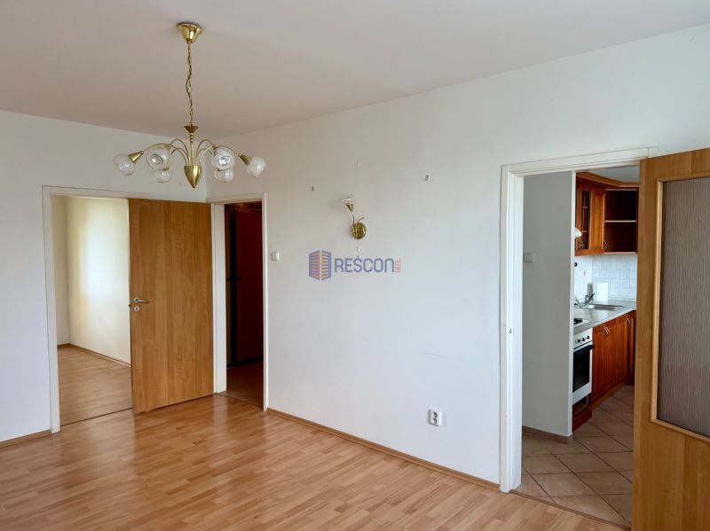 Interior of a 4-room apartment with a wooden decor floor and a chandelier.