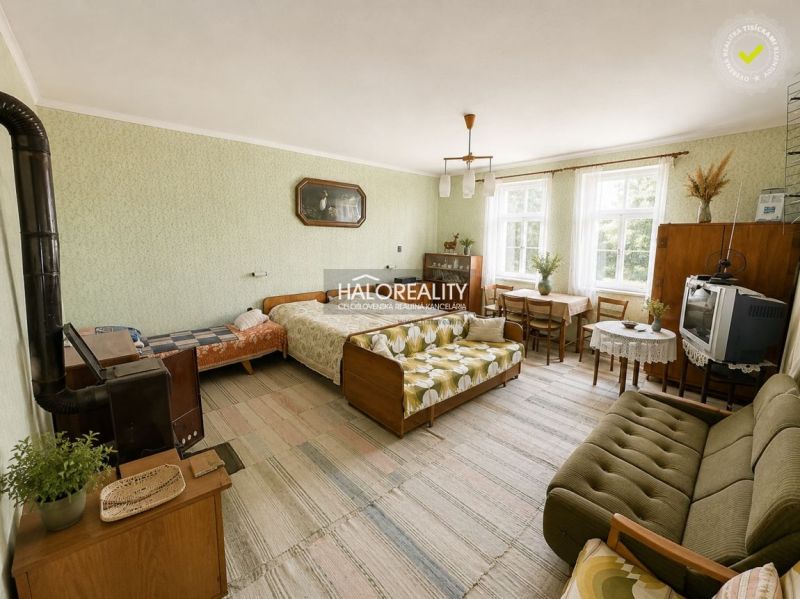 Living room with retro furniture in a family house, includes a sofa and a dining table.
