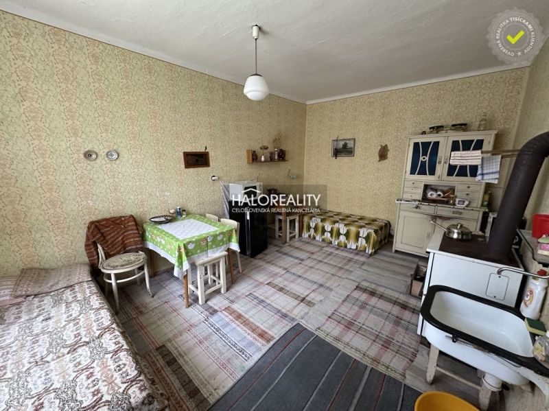 Interior of a family house with old furniture, carpets, and a wood-burning stove.