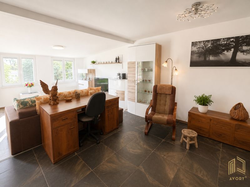 A living room in a cottage with a comfortable armchair and a wooden table.