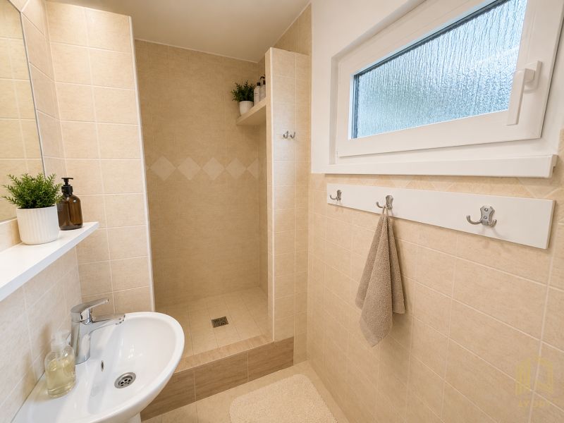 Bathroom with a shower, light tiles, and a plant, Cottage.