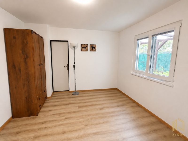 A cottage with a wooden wardrobe, a standing lamp, and a floor with a wooden decor.