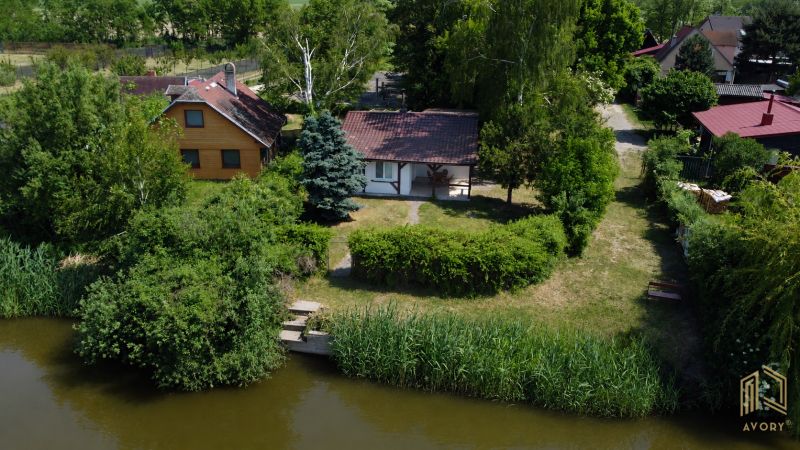 Green garden, a cottage by the water in Kopčany surrounded by greenery and trees.