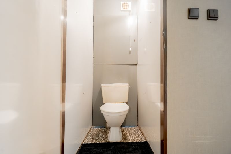 A bathroom in a 3-room apartment with white walls and a toilet.