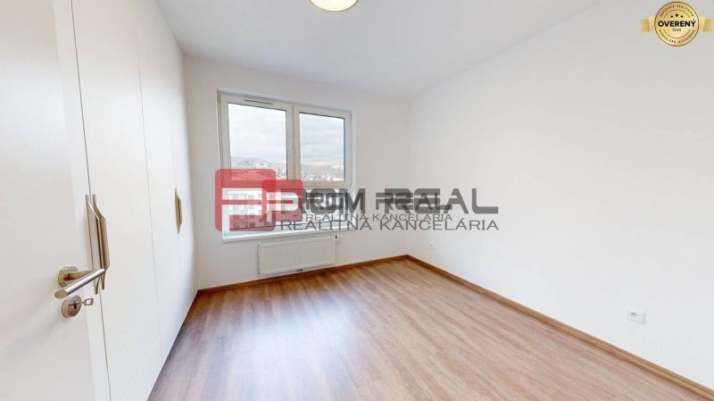 A bright room with wood-patterned flooring and white walls in a 3-room apartment.