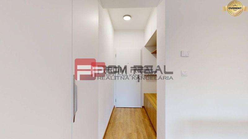 A hallway in a 3-room apartment with a wooden decor floor and storage space.