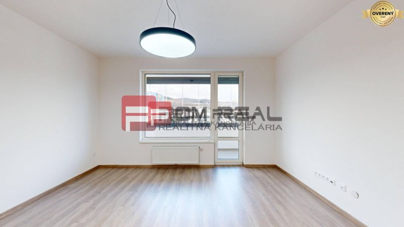 A room in a three-room apartment with a wooden decor floor and a large window.