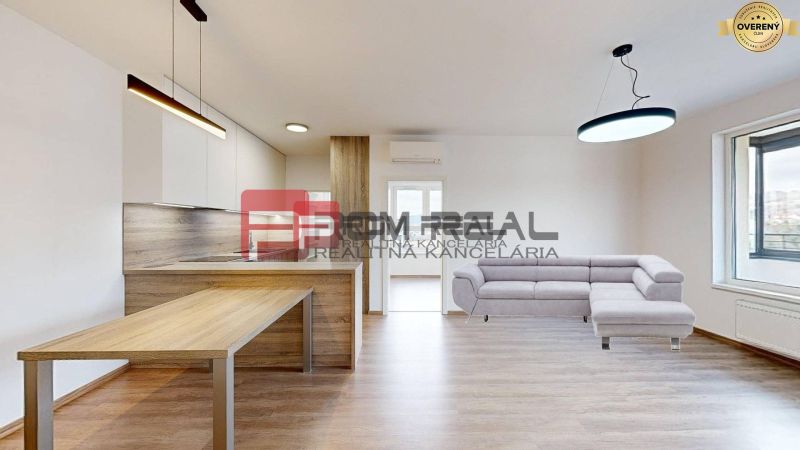 Living room of a 3-room apartment with a kitchen, wooden decor flooring, and a sofa.