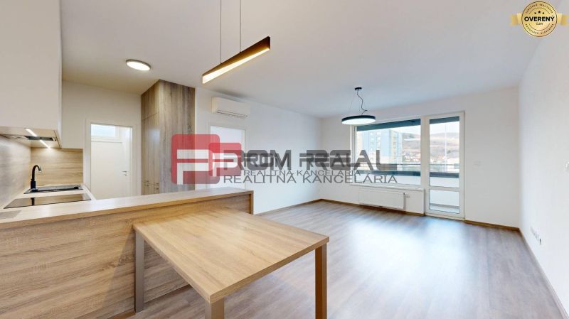 Living space in a 3-room apartment with a wooden decor floor and a kitchenette.