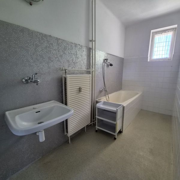 Bathroom in a 3-room apartment with a shower bath, sink, and window.