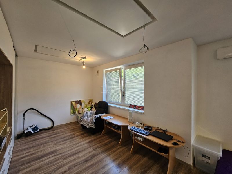 A room with a wooden floor and a table in a studio apartment.