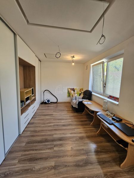 Interior of a 1-room apartment with a wooden decor floor and minimalist furniture.