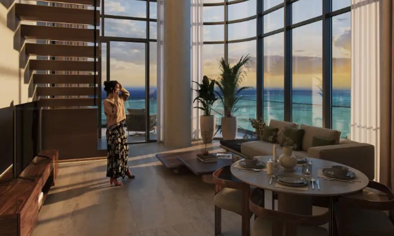 Spacious interior of a 1-bedroom apartment with large windows and a view of the sunset.