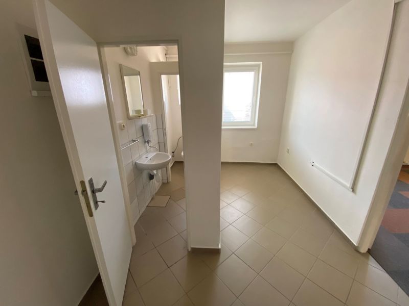 Commercial space with a sink, tiled floor, and white walls.