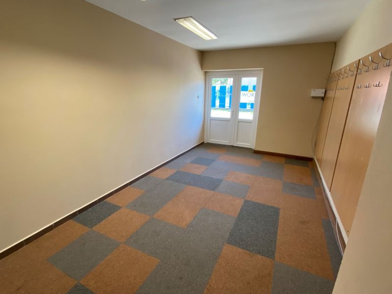Commercial space with hangers and geometric pattern on the wooden decor floor.