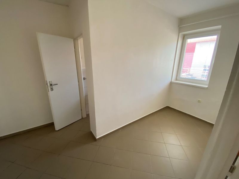 Room in commercial premises with white walls and tiles, neutral design.