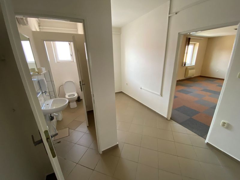 Commercial premises with sanitary facilities and a room with carpet flooring.