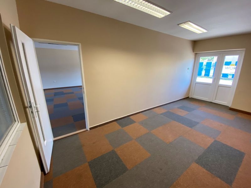 Interior of commercial spaces with multicolored flooring and glass doors.