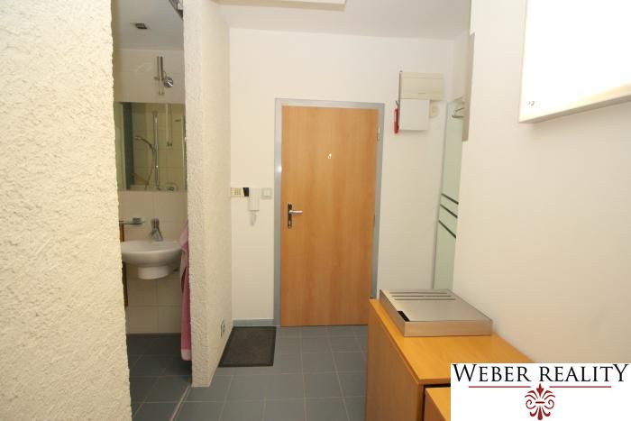 A hallway in a 3-room apartment with tiles and a mirror.