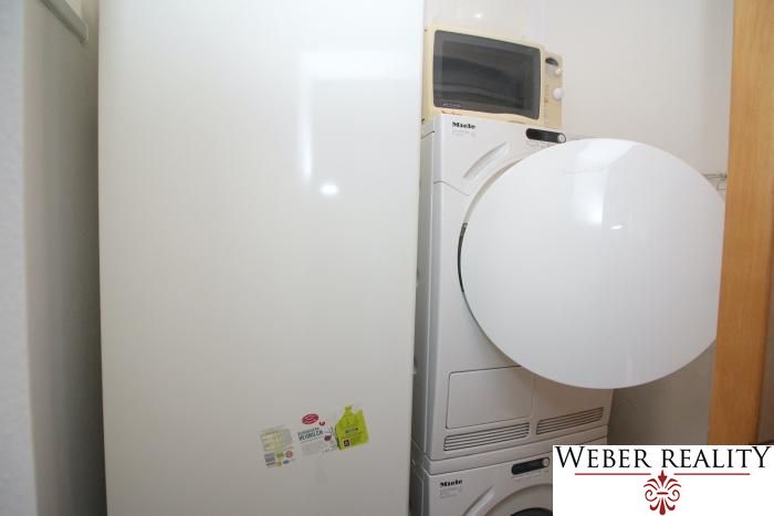 Washing machine and dryer in the bathroom of a 3-room apartment with a microwave.
