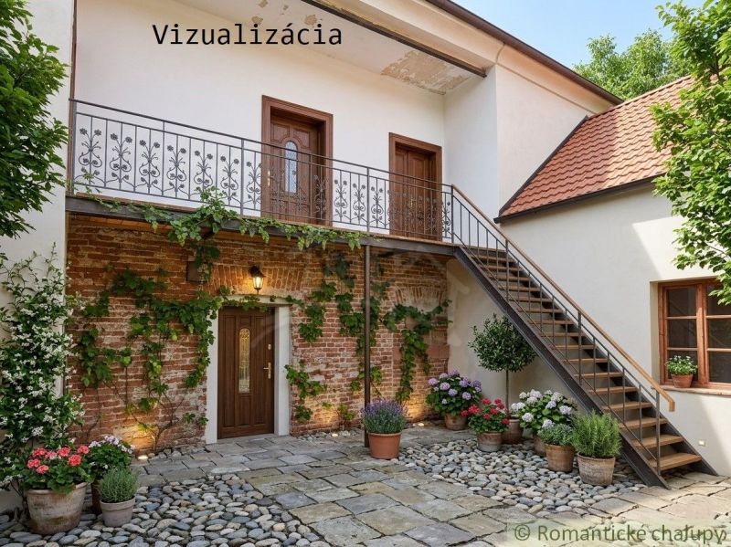 A family house in Klátova Nová Ves with a brick wall, wooden door, and staircase.