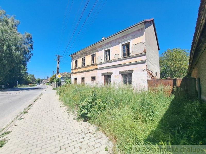 An abandoned family house in Klátova Nová Ves with damaged facade and overgrown land.