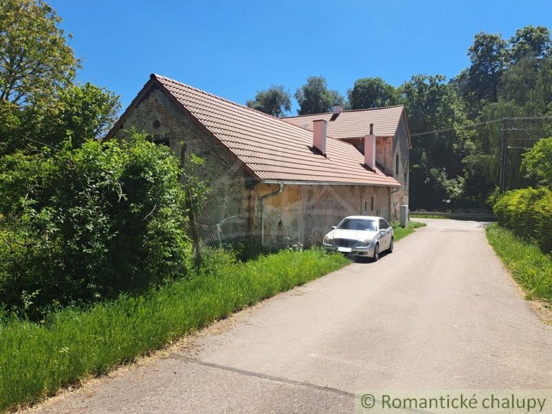 A family house in Klátova Nová Ves with a brick roof by the road and a parked car.
