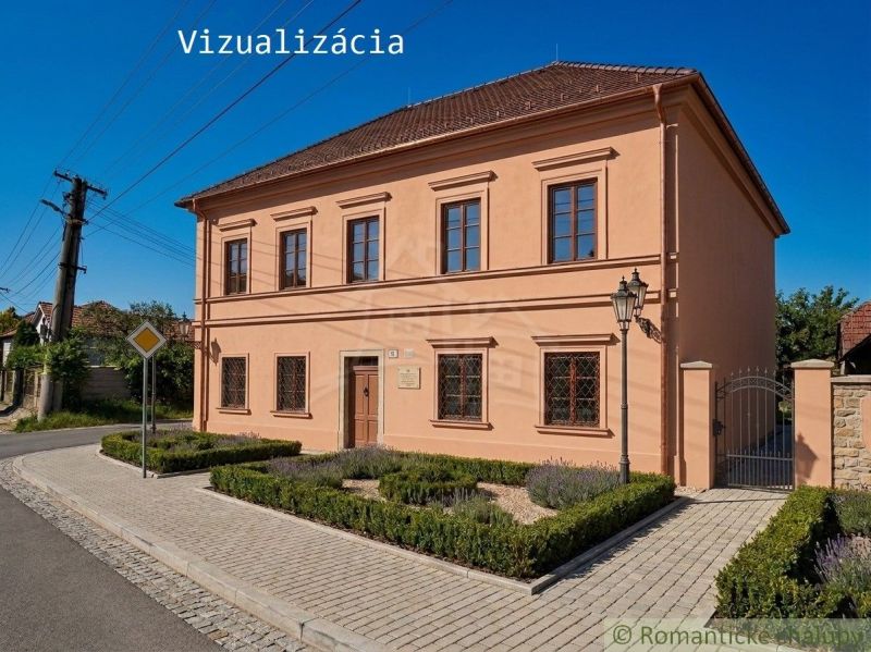 A family house in Klátova Nová Ves with windows, benches, and pavement on the street.
