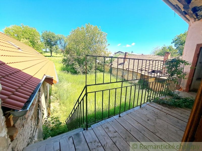 The view from the family house in Klátova Nová Ves to the garden with grass and trees.
