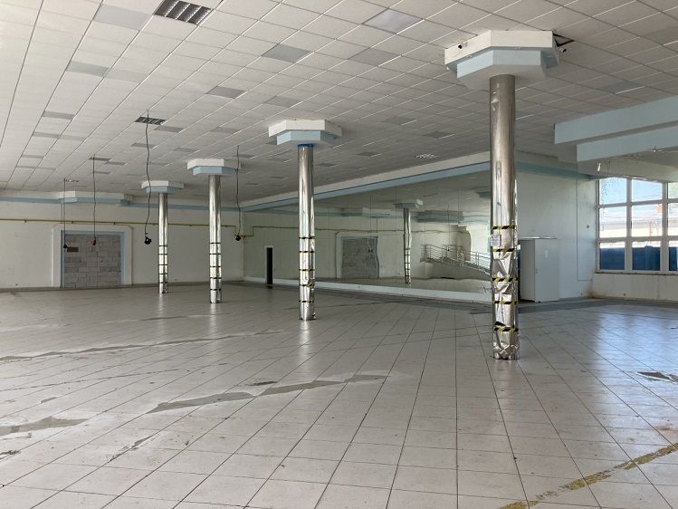 Commercial premises with tiles and columns, suitable for various activities.