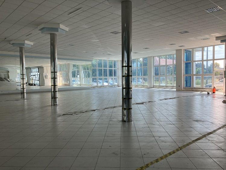 Spacious commercial spaces with glass walls and columns, drawing attention to the interior.