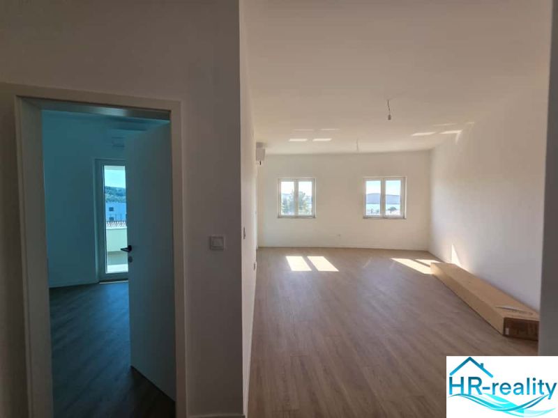 Interior of a 2-room apartment with a wooden decor floor and direct lighting.