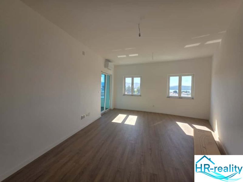 Bright living space with wood-patterned flooring in a 2-room apartment.