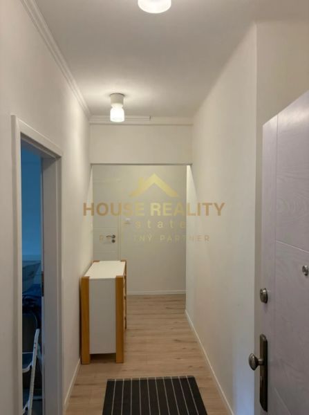 A hallway in a 3-room apartment with a wooden decor floor and white walls.