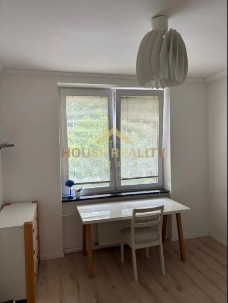 White desk, chair, and wooden decor flooring in a 3-room apartment.