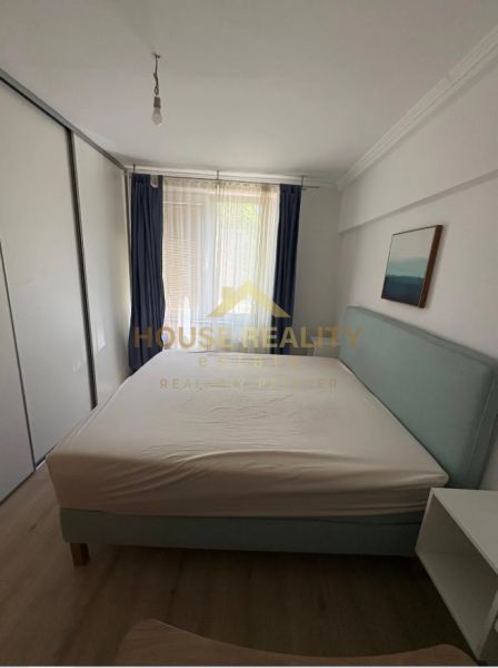 Bedroom in a 3-room apartment with a bed, blue curtains, and a built-in wardrobe.