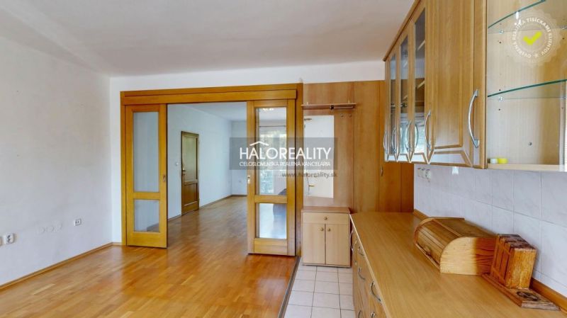 A kitchen unit in a 3-room apartment with sliding doors and a wooden decor floor.