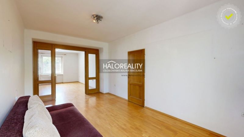 Living room in a 3-room apartment with a wooden decor floor and a comfortable couch.