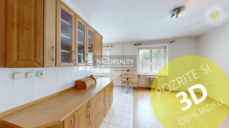 A kitchen in a 3-room apartment with wooden decor cabinets and a dining table.