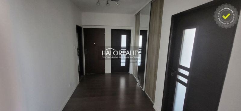 A hallway with a wooden decor floor and a built-in wardrobe in a 3-room apartment.