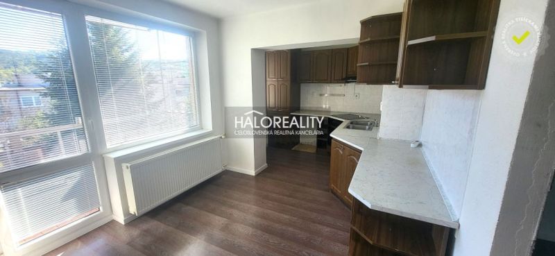 A kitchen in a 3-room apartment with a kitchen unit and a floor with a wooden decor.