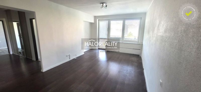 Living room in a 3-room apartment with wood-patterned flooring and large windows.