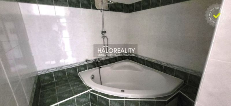 Corner bathtub with tiling in the bathroom of a 3-room apartment.