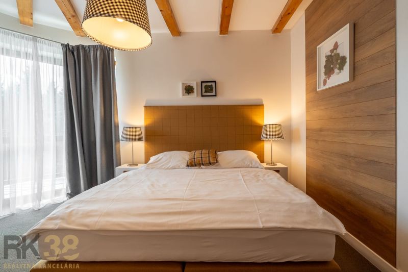 Bedroom with a double bed, lamps, and decoration in a 3-room apartment, floor with wooden decor.