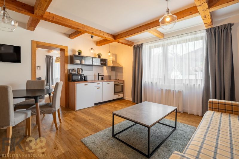 Living room with kitchen, wooden decor flooring, dining area and sofa.