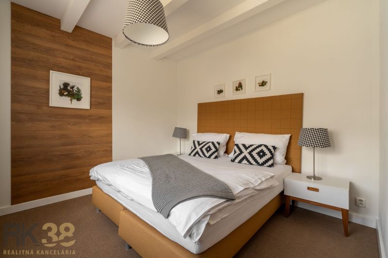 Bedroom in a 3-room apartment, with a bed and a wall with wooden decor.