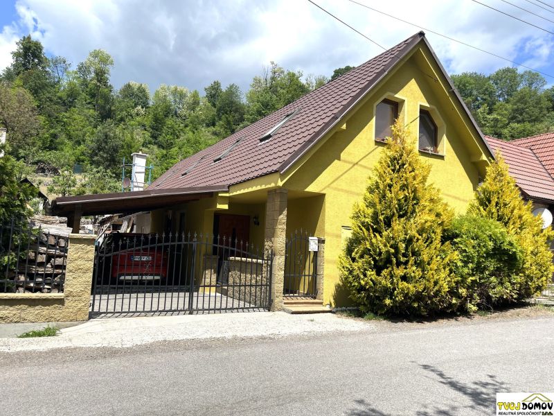A family house in Bartošova Lehôtka with a yellow facade, a brown roof, and a front garden.