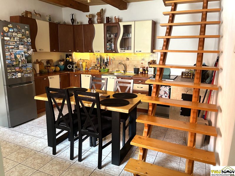A kitchen in a family house with wooden decor and stairs.